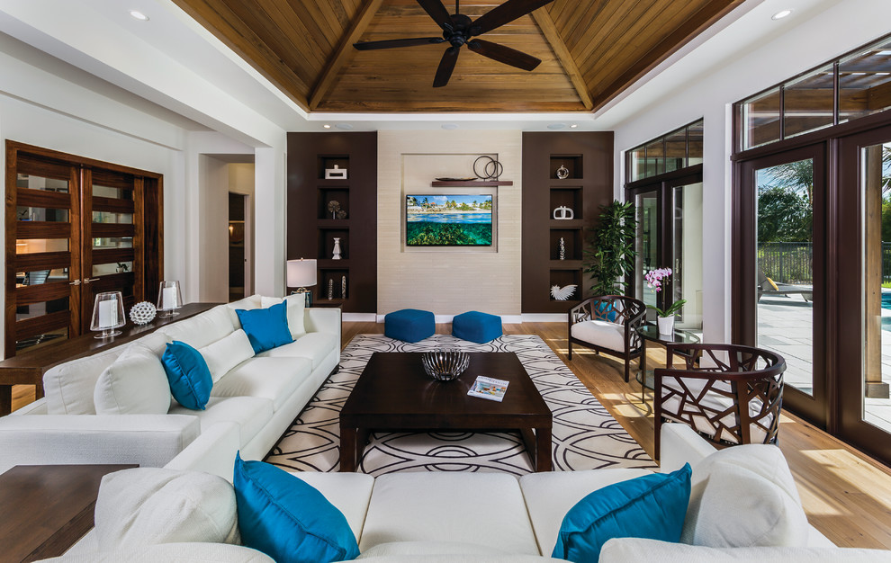 Design ideas for a large tropical open concept living room in Miami with white walls and a wall-mounted tv.