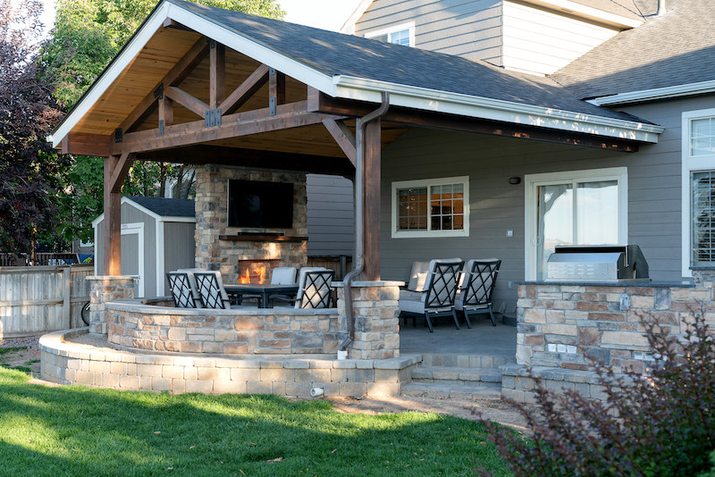 Esempio di un grande patio o portico minimalista dietro casa con un caminetto, cemento stampato e un tetto a sbalzo