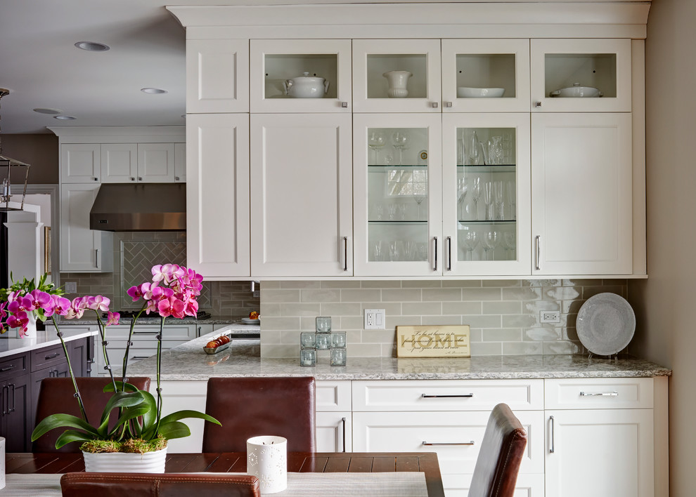 Example of a large transitional u-shaped medium tone wood floor open concept kitchen design in Chicago with a double-bowl sink, flat-panel cabinets, white cabinets, quartz countertops, beige backsplash, subway tile backsplash, stainless steel appliances and an island