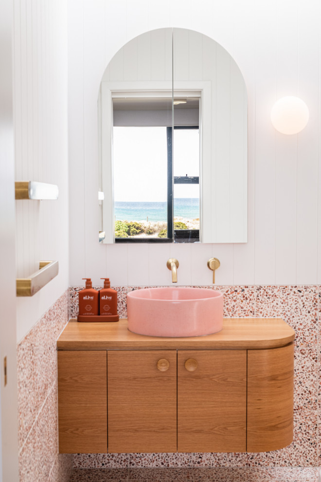 Photo of a mid-sized beach style bathroom in Adelaide with furniture-like cabinets, terrazzo floors, a vessel sink, wood benchtops, multi-coloured floor, brown benchtops, a single vanity, a floating vanity, planked wall panelling and medium wood cabinets.