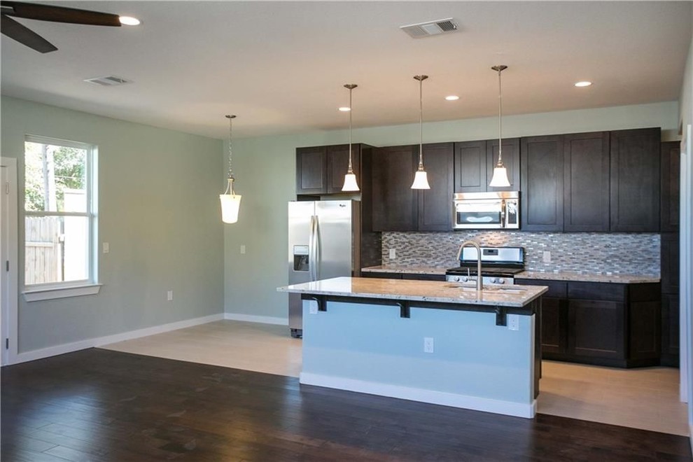 Eat-in kitchen - mid-sized transitional single-wall porcelain tile and beige floor eat-in kitchen idea in Austin with a double-bowl sink, shaker cabinets, dark wood cabinets, granite countertops, gray backsplash, mosaic tile backsplash, stainless steel appliances, an island and gray countertops