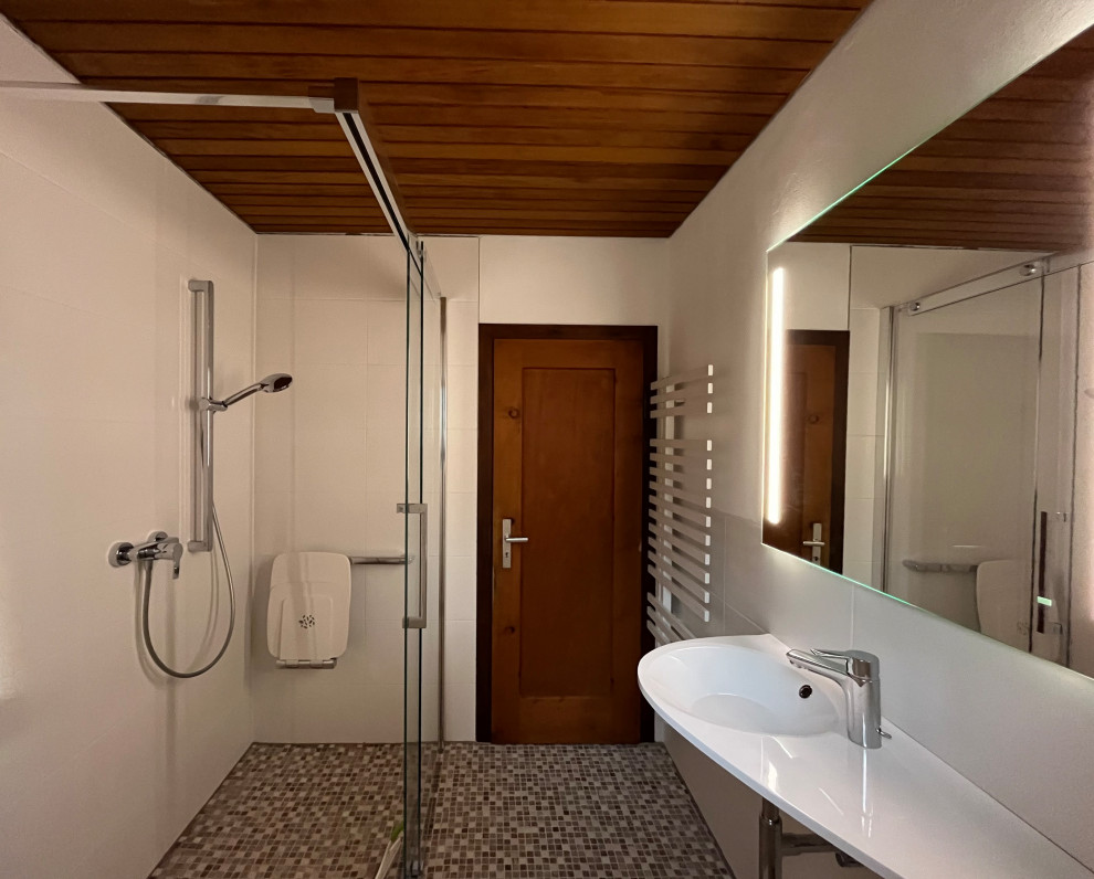 Idées déco pour une petite salle de bain contemporaine avec une douche à l'italienne, WC suspendus, un carrelage blanc, des carreaux de céramique, un mur blanc, un sol en carrelage de terre cuite, un lavabo suspendu, un plan de toilette en surface solide, un sol beige, une cabine de douche à porte coulissante, un plan de toilette blanc, meuble simple vasque, meuble-lavabo suspendu, un plafond en lambris de bois et un mur en pierre.