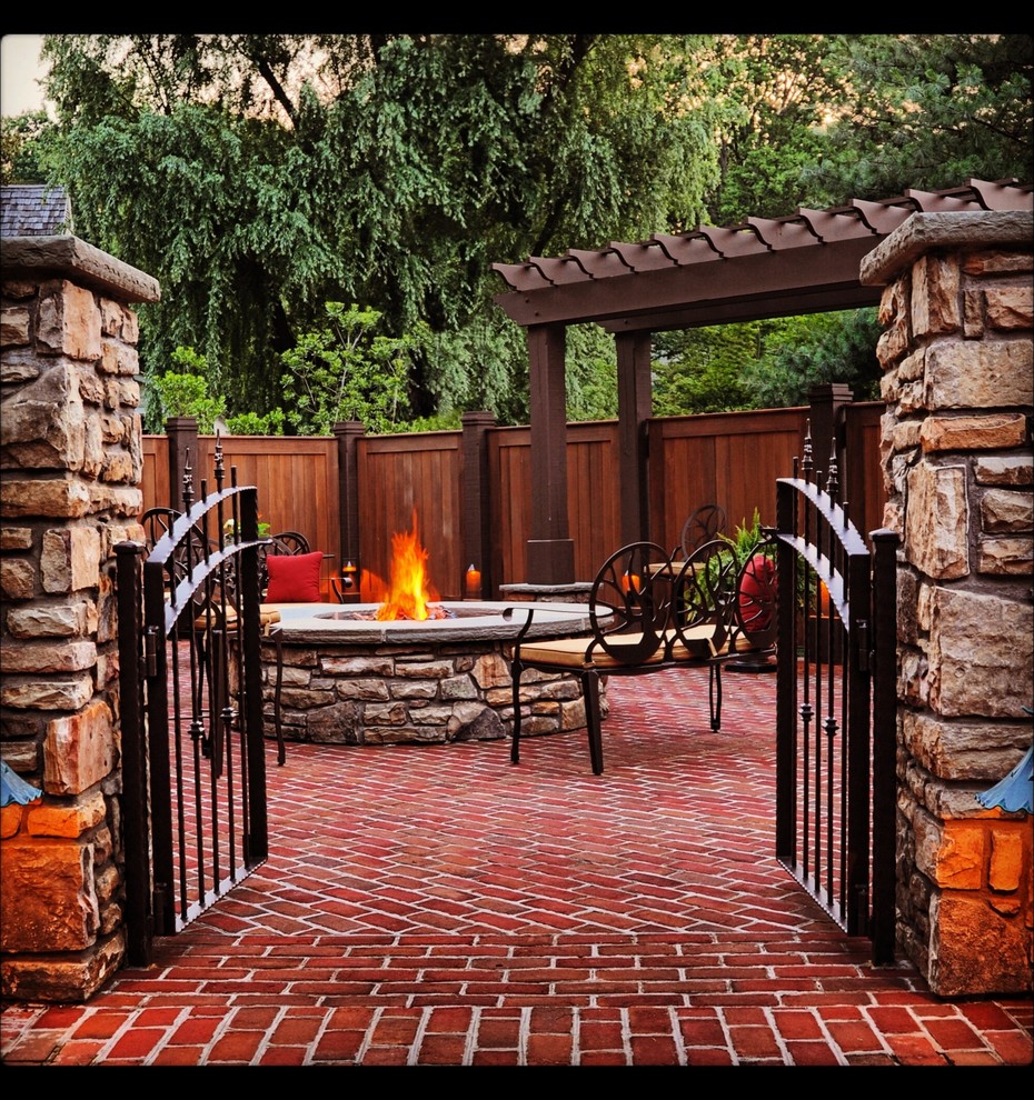 Photo of a mid-sized traditional backyard patio in Other with a fire feature, brick pavers and a pergola.