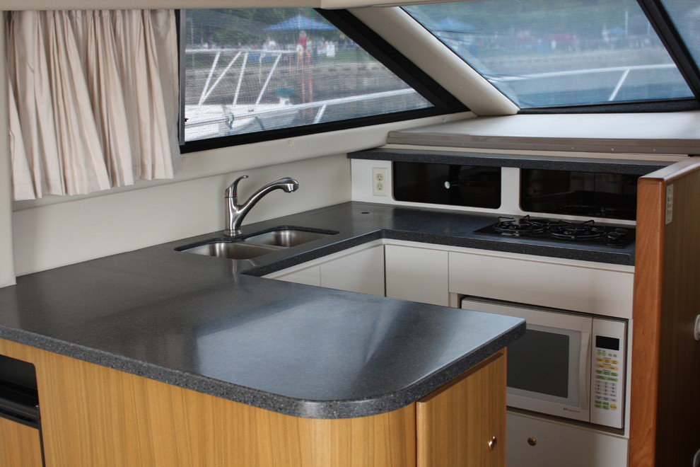 Inspiration for a small transitional u-shaped eat-in kitchen remodel with a double-bowl sink, flat-panel cabinets, white cabinets, quartz countertops, white appliances and a peninsula