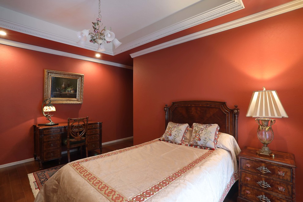 Exemple d'une chambre chic avec un mur rouge, parquet foncé et un sol marron.