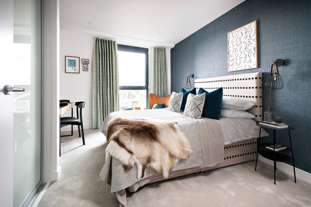 This is an example of a mid-sized contemporary master bedroom in London with blue walls, carpet, grey floor and wallpaper.