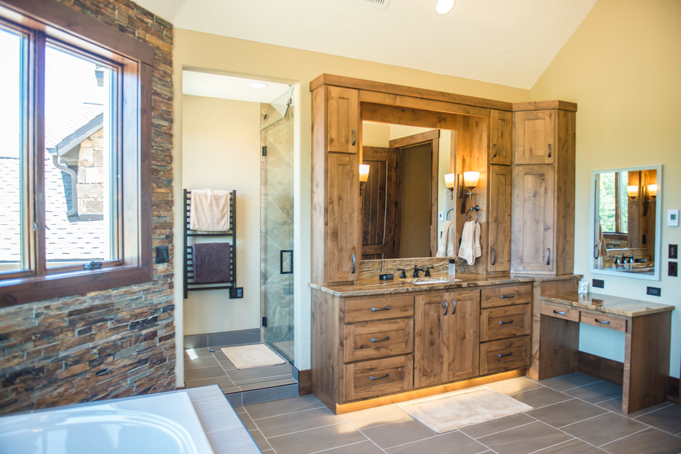 Example of a huge mountain style master slate tile porcelain tile and brown floor freestanding bathtub design in Chicago with flat-panel cabinets, medium tone wood cabinets, a one-piece toilet, multicolored walls, an undermount sink, marble countertops and a hinged shower door