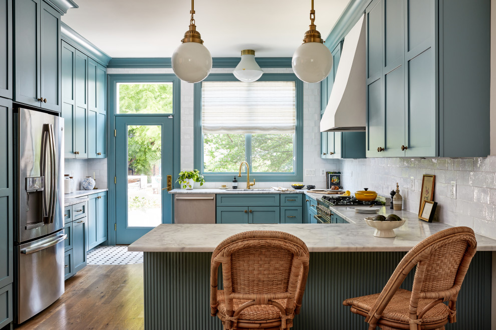 Стильный дизайн: большая кухня в стиле неоклассика (современная классика) с обеденным столом, фасадами в стиле шейкер, синими фасадами, мраморной столешницей и белым фартуком - последний тренд