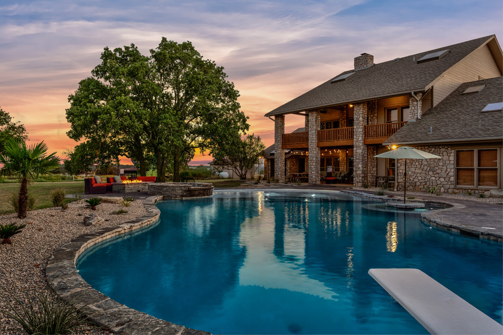 Photo of an expansive arts and crafts backyard custom-shaped pool in Dallas with a hot tub and stamped concrete.