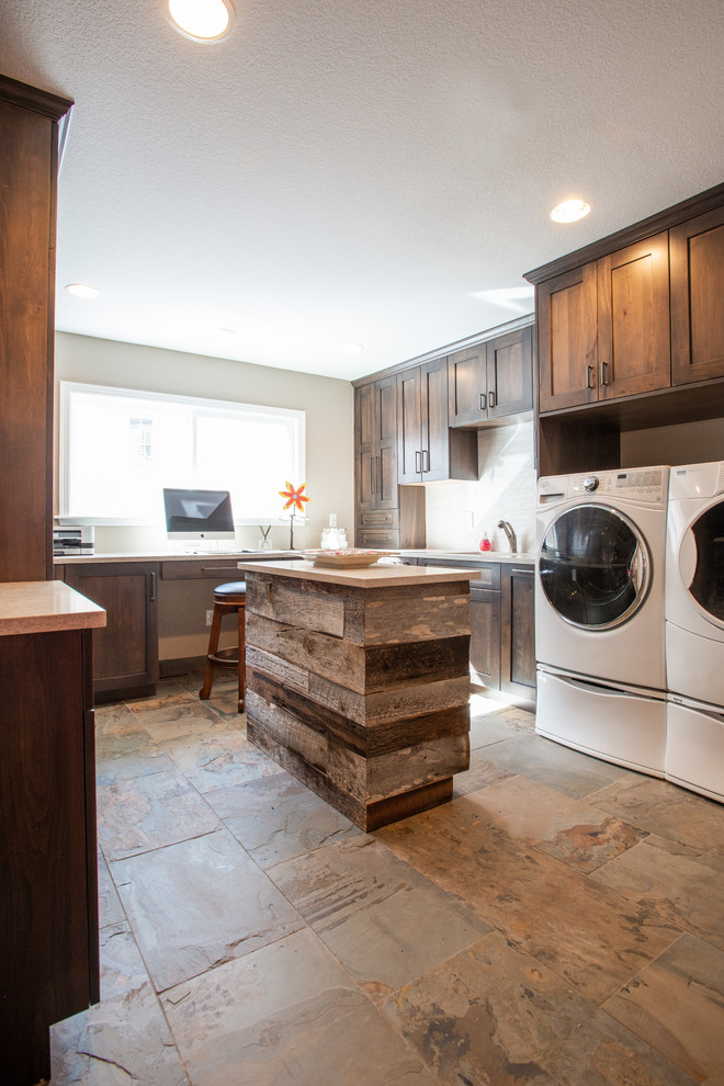 This is an example of a large country u-shaped utility room in Other with an undermount sink, flat-panel cabinets, dark wood cabinets, quartz benchtops, grey walls, slate floors, a side-by-side washer and dryer, multi-coloured floor and white benchtop.