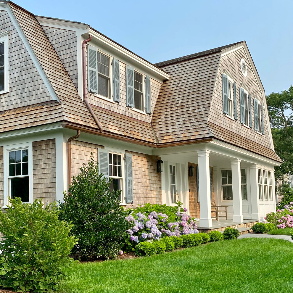 Beach style house exterior in Boston with wood siding, a gambrel roof, a shingle roof and shingle siding.