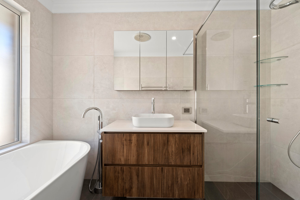 Mid-sized mediterranean master bathroom in Perth with shaker cabinets, dark wood cabinets, a freestanding tub, a corner shower, a one-piece toilet, beige tile, ceramic tile, beige walls, ceramic floors, a vessel sink, grey floor and a hinged shower door.