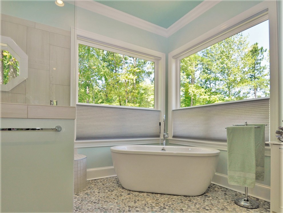 This is an example of a large transitional master bathroom in Wilmington with recessed-panel cabinets, grey cabinets, a freestanding tub, an open shower, a one-piece toilet, beige tile, pebble tile, blue walls, pebble tile floors, an undermount sink, limestone benchtops, multi-coloured floor, an open shower and multi-coloured benchtops.