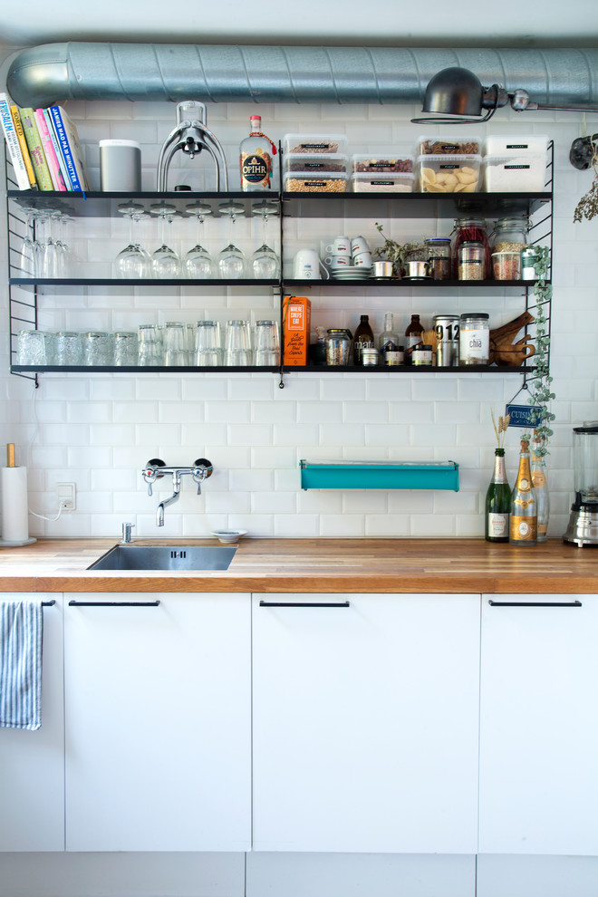 This is an example of a small scandinavian open plan kitchen in Copenhagen with a single-bowl sink, open cabinets, no island and laminate benchtops.