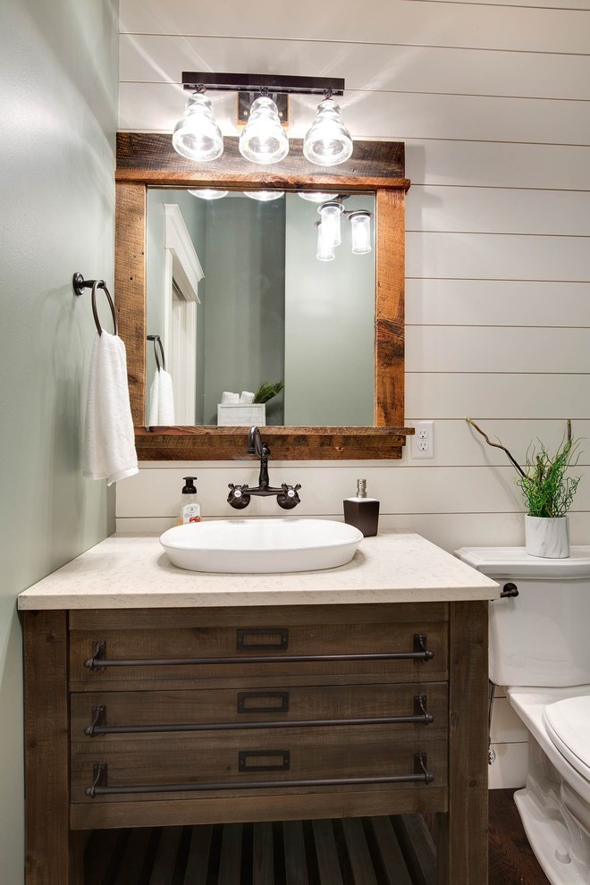 Country powder room in Minneapolis with a two-piece toilet, dark hardwood floors, a vessel sink, dark wood cabinets and engineered quartz benchtops.