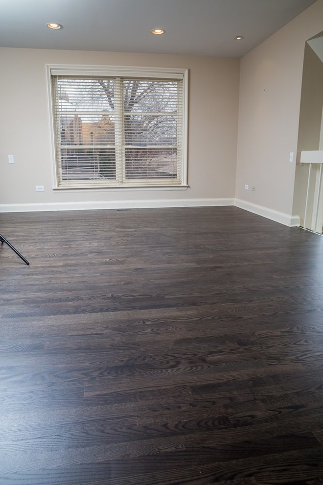 This is an example of a mid-sized transitional family room in Chicago with dark hardwood floors, beige walls and brown floor.