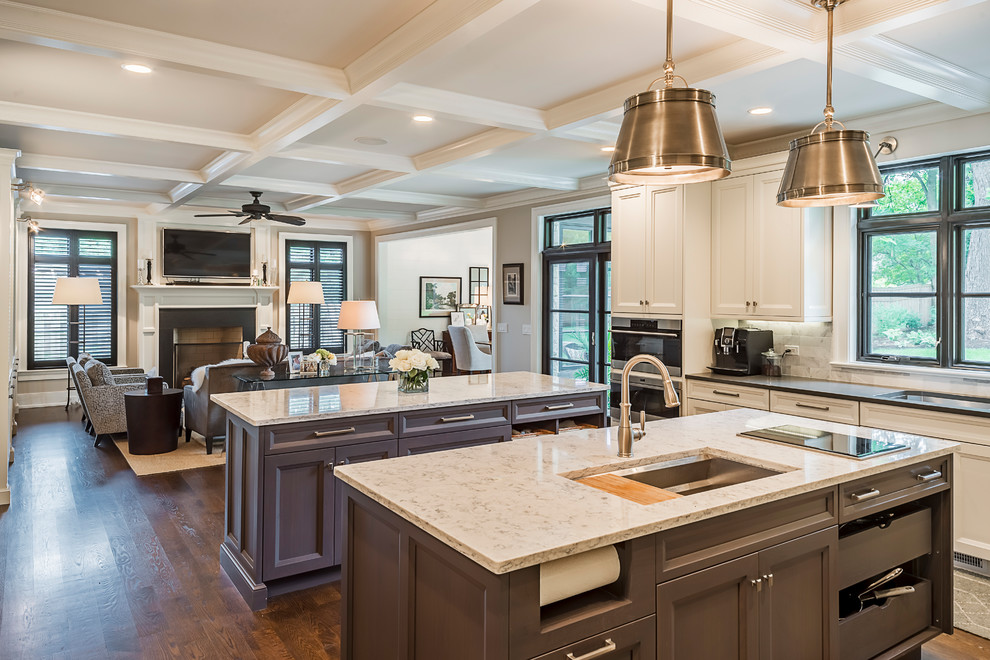 Design ideas for an expansive traditional l-shaped open plan kitchen in Chicago with an undermount sink, shaker cabinets, beige cabinets, quartz benchtops, white splashback, subway tile splashback, stainless steel appliances, dark hardwood floors, multiple islands and brown floor.