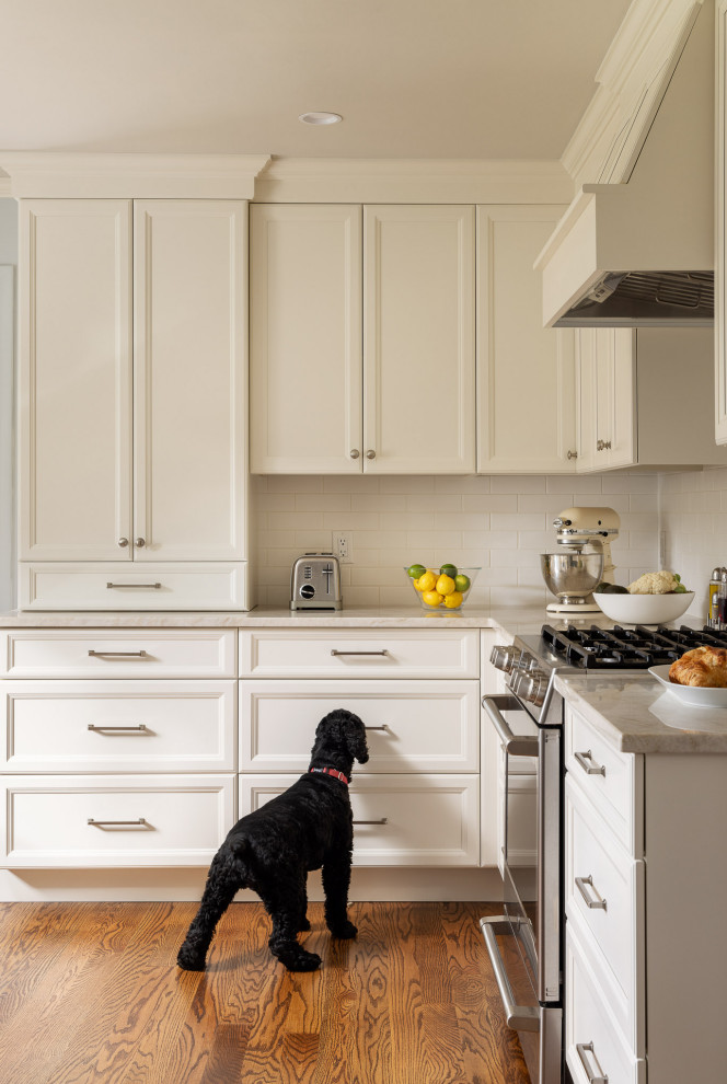 Inspiration for a mid-sized transitional l-shaped separate kitchen in New York with an undermount sink, recessed-panel cabinets, beige cabinets, quartzite benchtops, yellow splashback, subway tile splashback, panelled appliances, medium hardwood floors, a peninsula and beige benchtop.