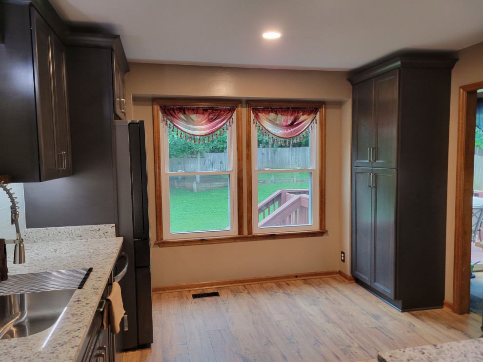 Aménagement d'une arrière-cuisine classique en U et bois foncé de taille moyenne avec un placard à porte shaker et un plan de travail en granite.