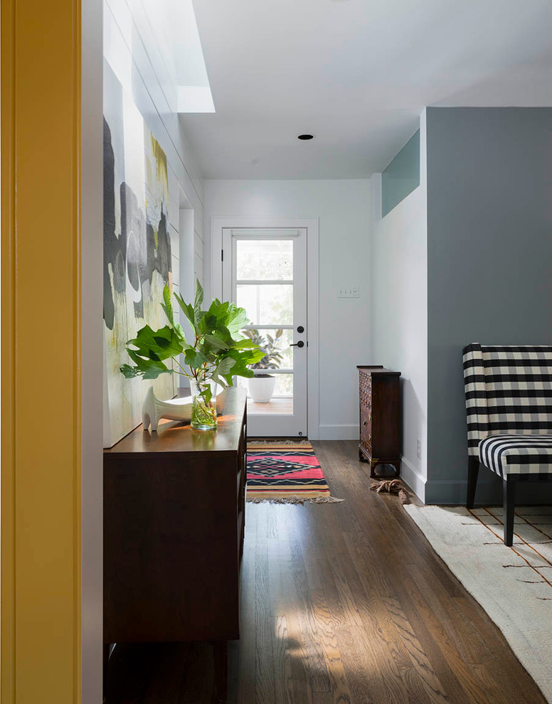 This is an example of a small transitional entryway in Austin with grey walls, medium hardwood floors, a single front door and a glass front door.