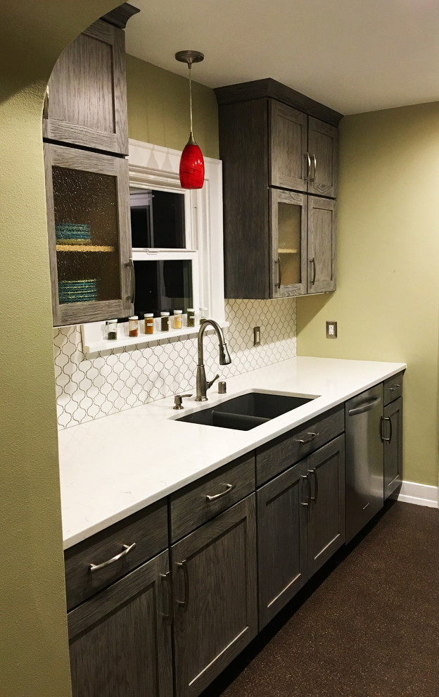Inspiration for a small transitional galley enclosed kitchen remodel in Seattle with an undermount sink, shaker cabinets, gray cabinets, quartzite countertops, white backsplash, ceramic backsplash, stainless steel appliances and no island