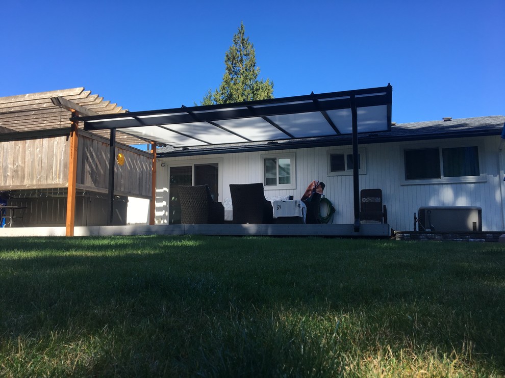 This is an example of a mid-sized traditional backyard patio in Phoenix with decking and a roof extension.