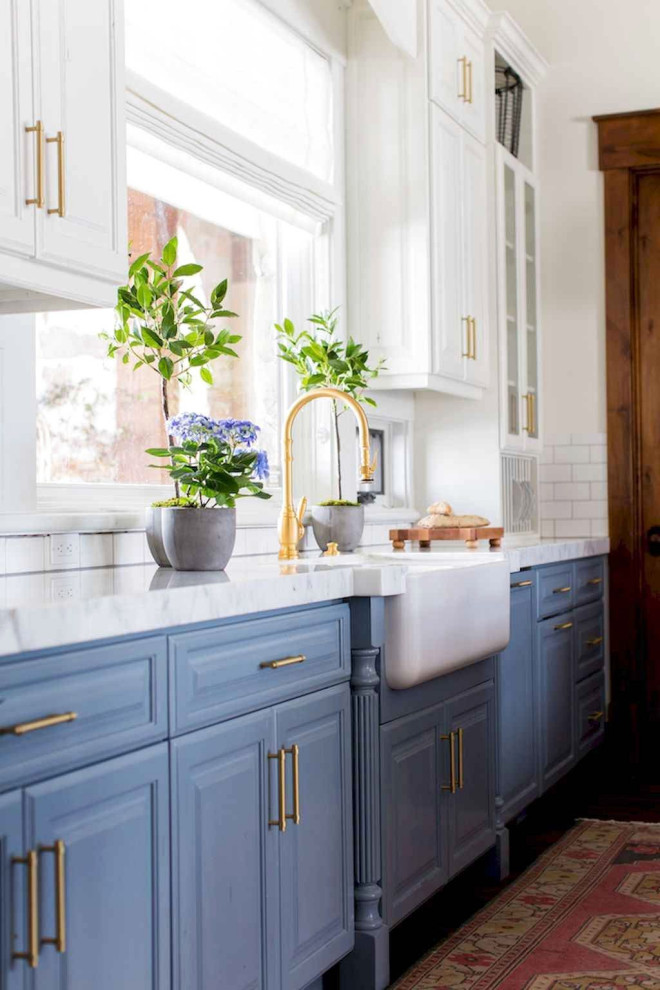 Eat-in kitchen - mid-sized traditional light wood floor and brown floor eat-in kitchen idea in Columbus with a farmhouse sink, raised-panel cabinets, blue cabinets, quartz countertops, white backsplash, ceramic backsplash, stainless steel appliances and white countertops