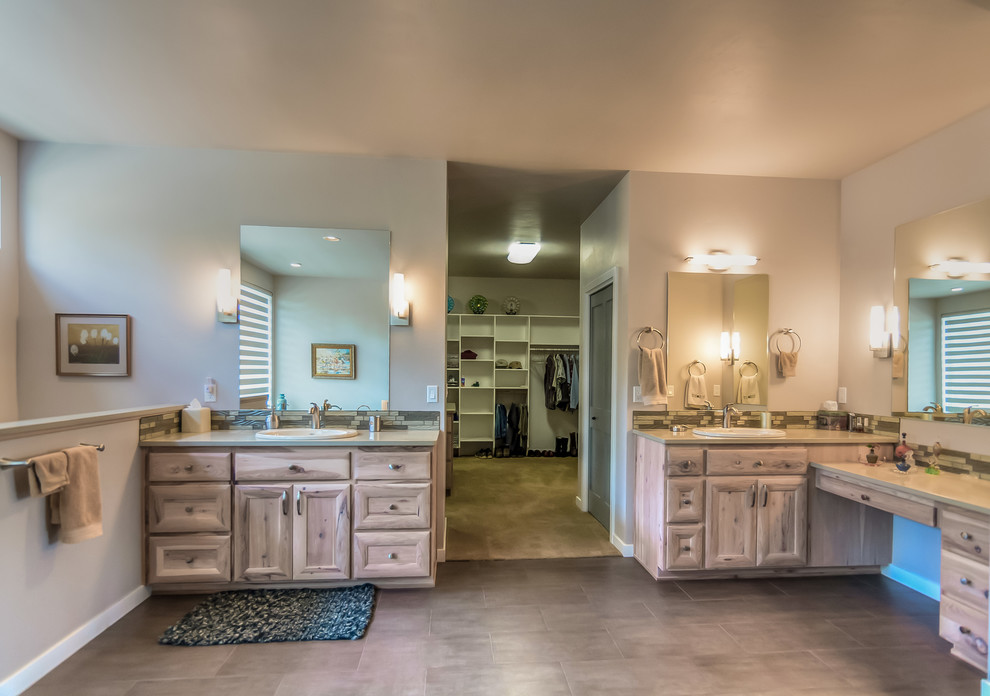 Example of a huge mountain style master ceramic tile porcelain tile and beige floor corner shower design with recessed-panel cabinets, light wood cabinets, a hot tub, beige walls, a drop-in sink and solid surface countertops