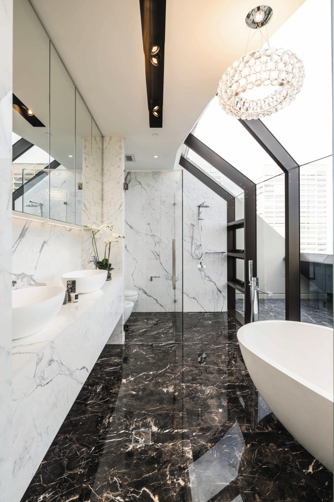 Inspiration for a large contemporary bathroom in Sydney with a freestanding tub, an open shower, a bidet, black and white tile, marble, marble floors, a vessel sink, marble benchtops, black floor, an open shower, a double vanity and a built-in vanity.
