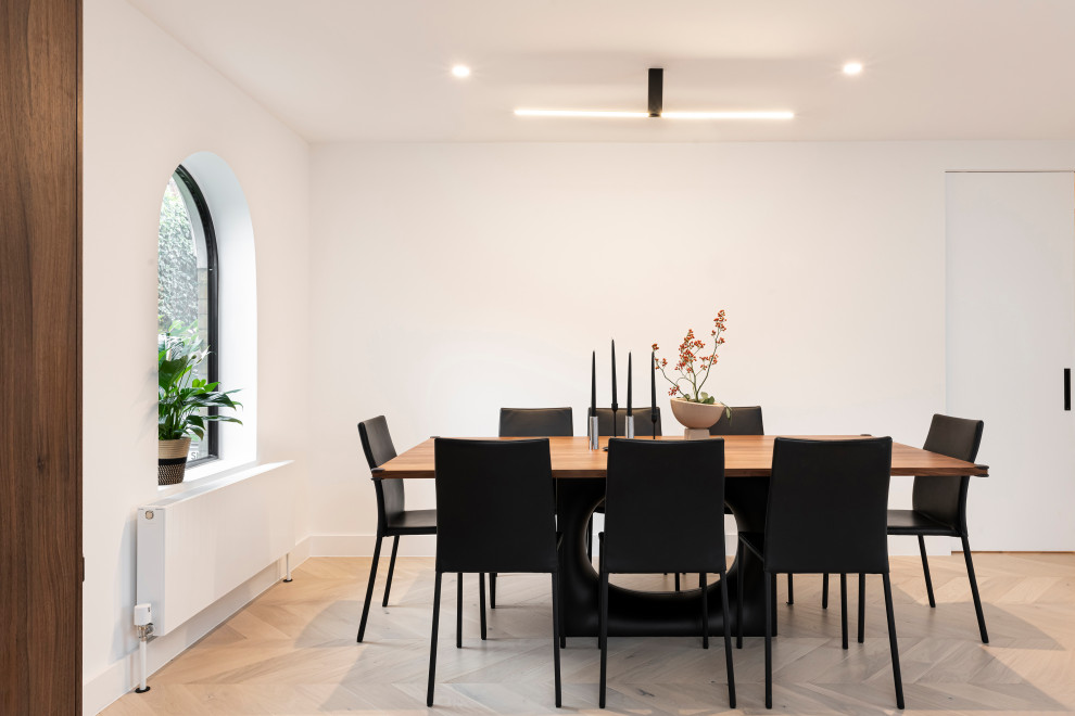 Design ideas for a large contemporary dining room in London with light hardwood flooring.