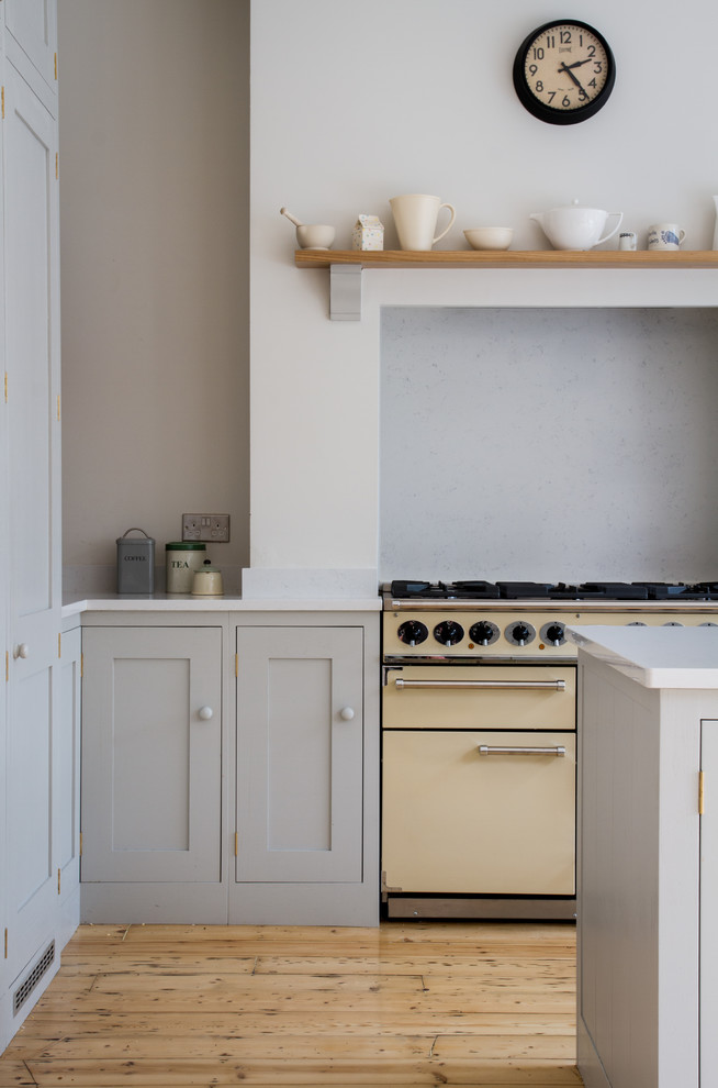 This is an example of a large scandinavian l-shaped eat-in kitchen in Other with a farmhouse sink, shaker cabinets, white cabinets, quartz benchtops, coloured appliances and with island.
