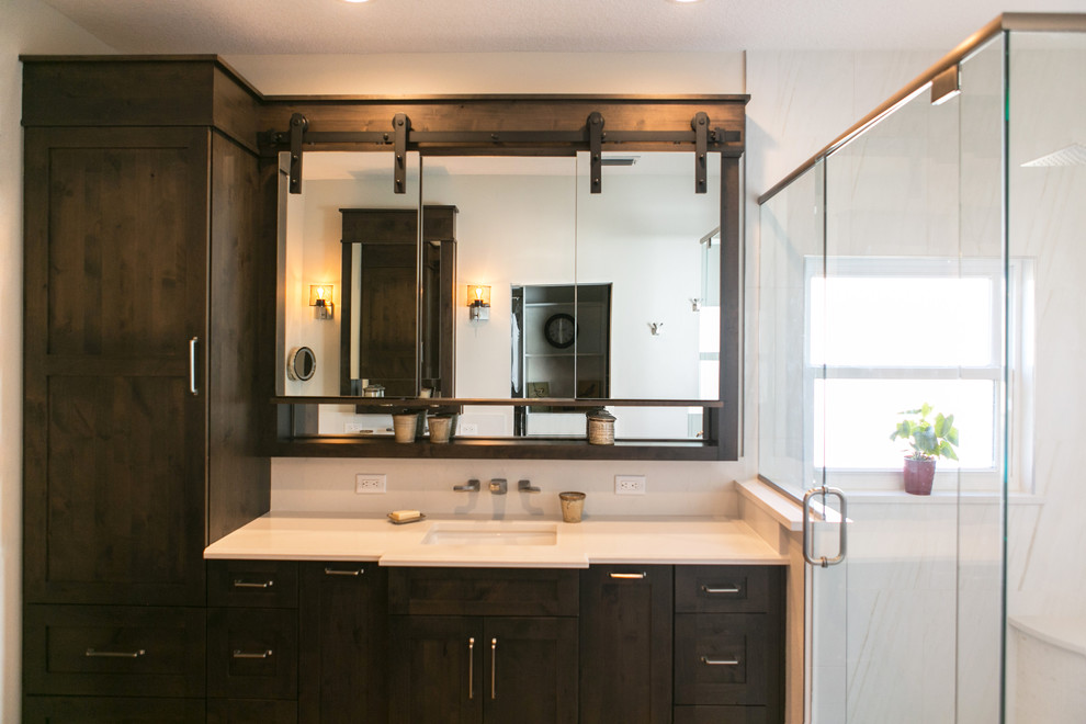 Design ideas for a mid-sized transitional master bathroom in Orlando with recessed-panel cabinets, dark wood cabinets, a corner shower, white tile, porcelain tile, grey walls, an undermount sink, quartzite benchtops and a hinged shower door.