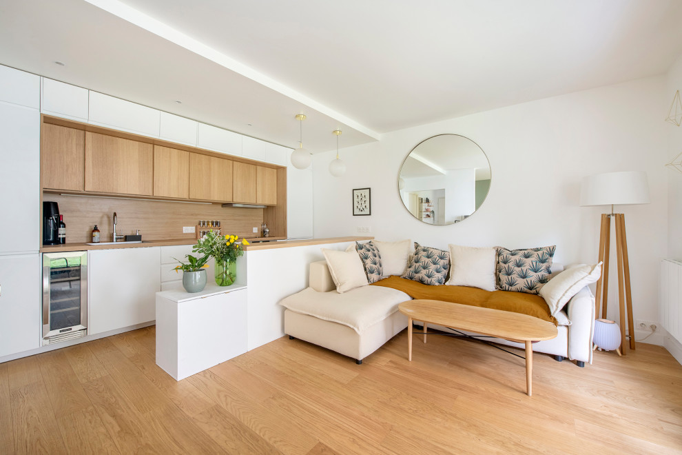 Imagen de salón abierto moderno de tamaño medio sin chimenea con paredes blancas, suelo de madera clara, televisor independiente y suelo beige