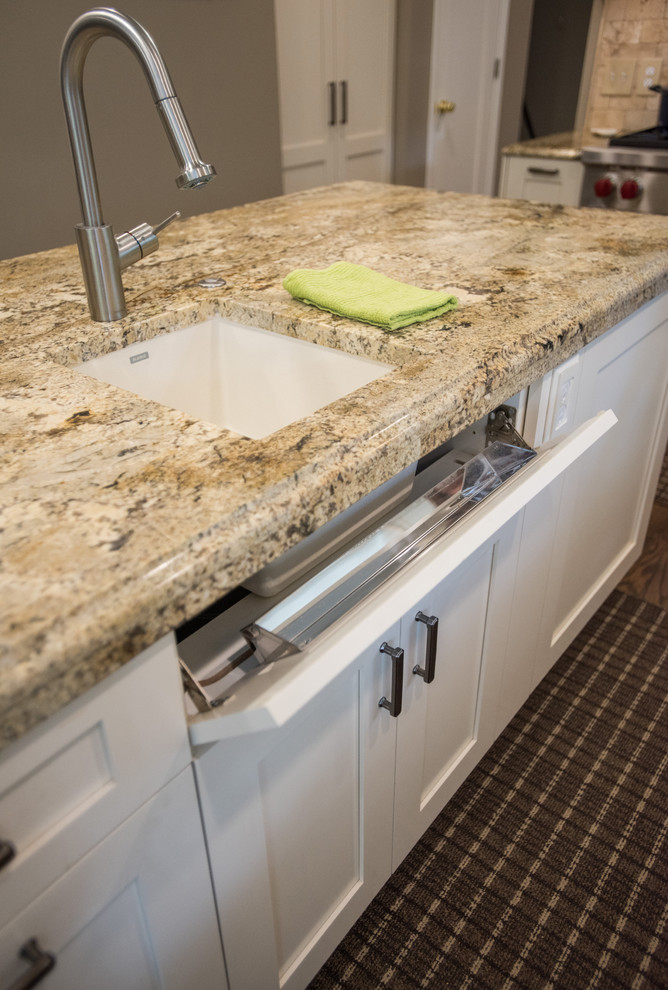 Inspiration for a large transitional u-shaped medium tone wood floor and brown floor eat-in kitchen remodel with an undermount sink, shaker cabinets, white cabinets, granite countertops, beige backsplash, paneled appliances and an island