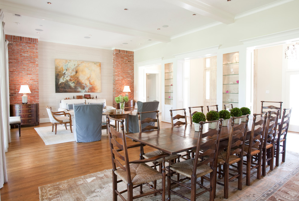 This is an example of a large transitional open plan dining in Houston with beige walls and medium hardwood floors.