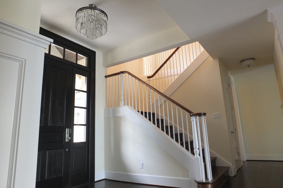 Photo of a large contemporary foyer in Portland with yellow walls, dark hardwood floors, a single front door and a dark wood front door.