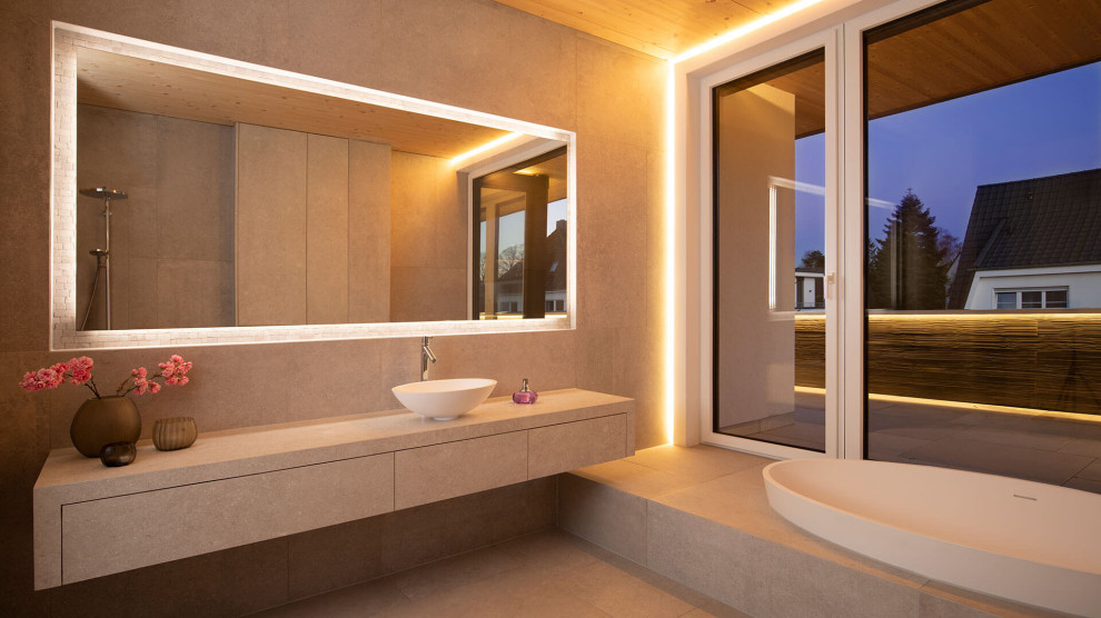 Design ideas for a large contemporary 3/4 bathroom in Dortmund with a drop-in tub, a curbless shower, a two-piece toilet, beige tile, stone tile, beige walls, ceramic floors, a vessel sink, solid surface benchtops, beige floor, an open shower, beige benchtops, a single vanity, a floating vanity and wood.
