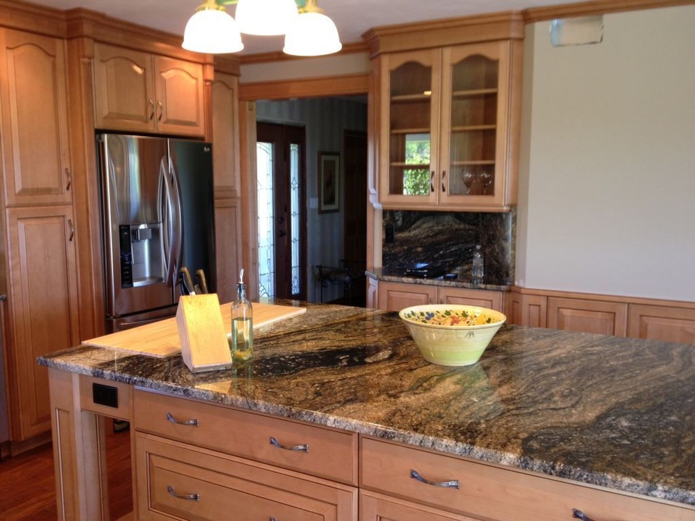Example of a mid-sized transitional l-shaped medium tone wood floor kitchen pantry design in Toronto with granite countertops, an island, a double-bowl sink, raised-panel cabinets, medium tone wood cabinets, multicolored backsplash, stone slab backsplash and stainless steel appliances