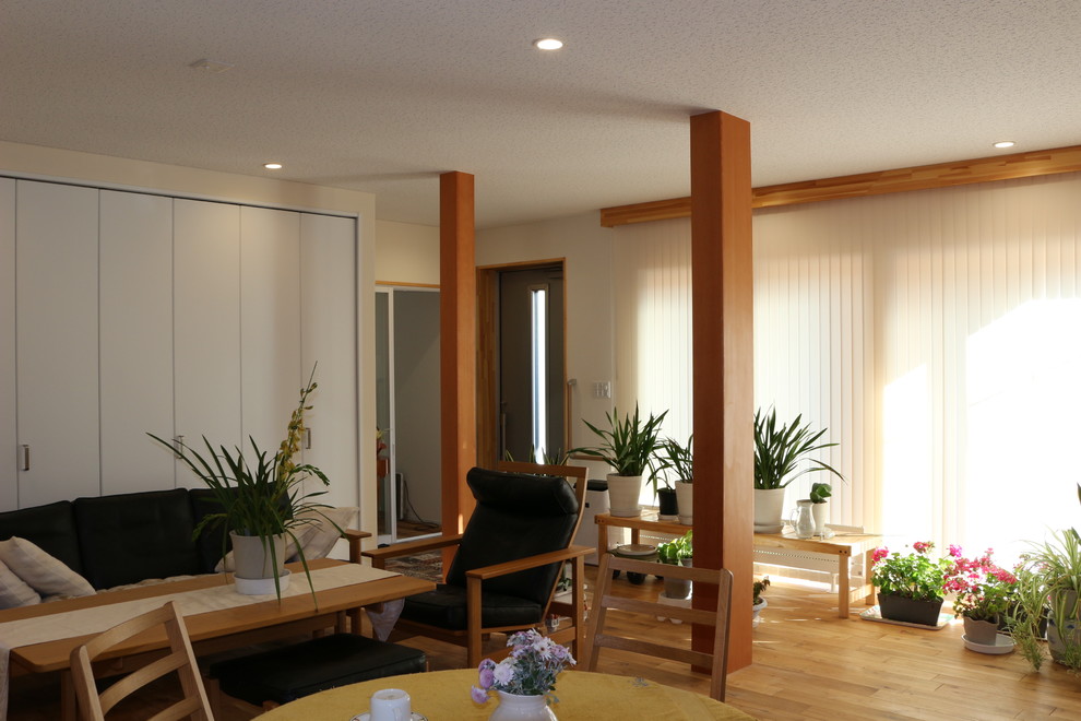 Design ideas for a large scandinavian open concept living room in Other with beige walls, medium hardwood floors, no fireplace, a freestanding tv and beige floor.