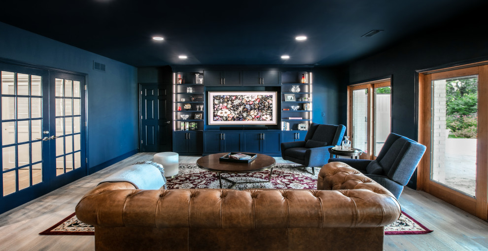 This is an example of a large transitional basement in St Louis with a home bar, blue walls, medium hardwood floors and brown floor.