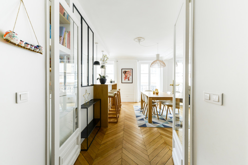 Aménagement d'une salle de séjour contemporaine de taille moyenne et fermée avec un mur blanc, parquet clair, aucune cheminée, aucun téléviseur et un sol marron.