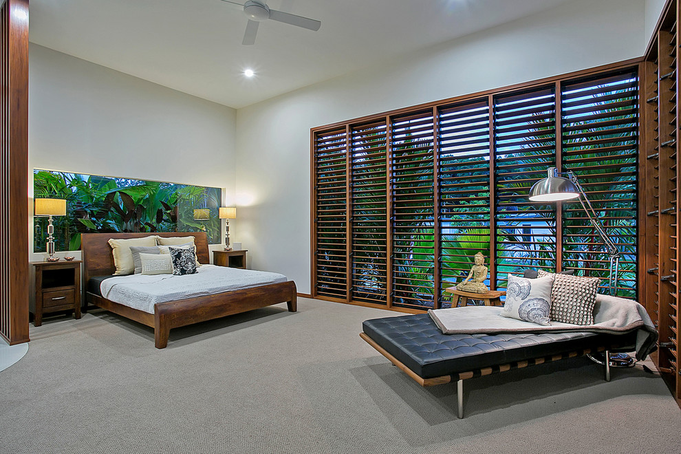 Photo of an expansive tropical master bedroom in Cairns with carpet.