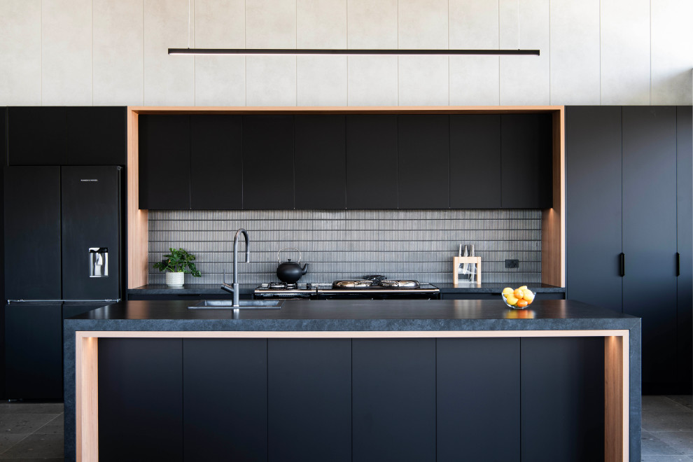 Large kitchen photo in Sydney with flat-panel cabinets, black cabinets, quartz countertops, gray backsplash, porcelain backsplash and black countertops