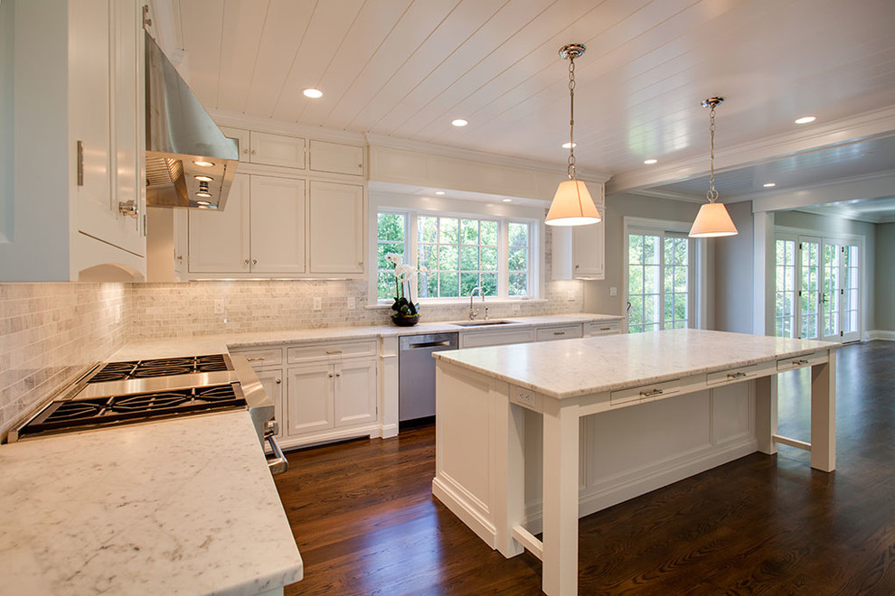 Large transitional u-shaped dark wood floor and brown floor eat-in kitchen photo with an undermount sink, recessed-panel cabinets, white cabinets, white backsplash, stainless steel appliances and an island