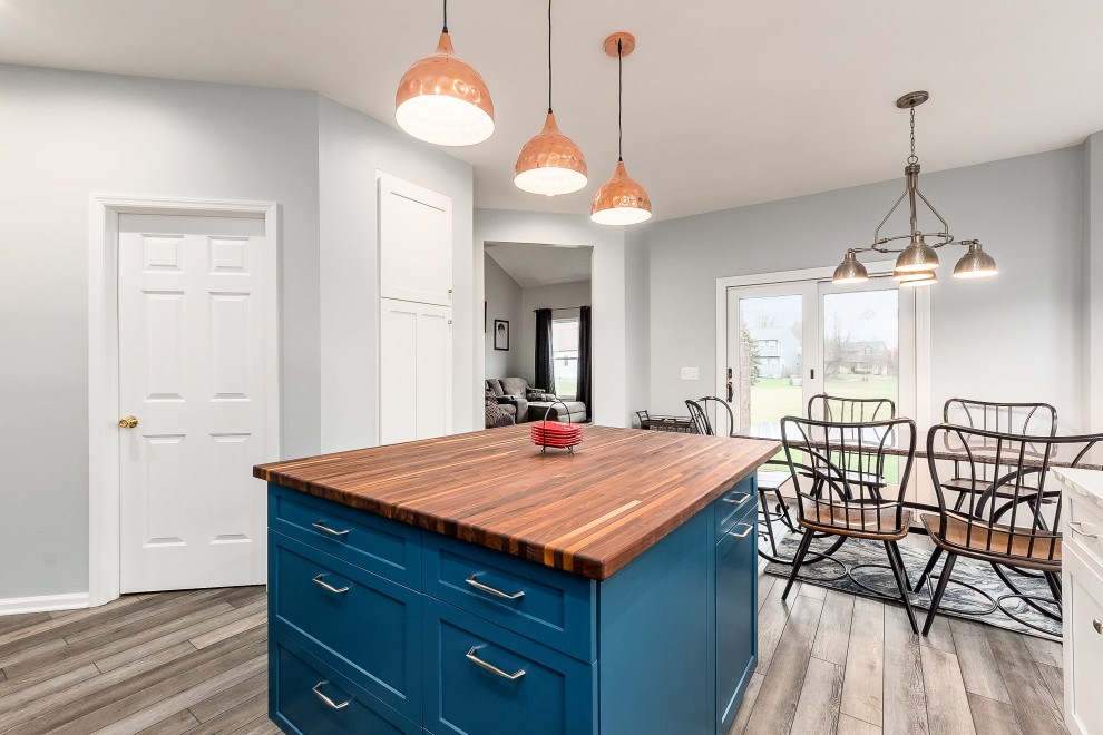 Inspiration for a mid-sized transitional l-shaped eat-in kitchen remodel in Columbus with shaker cabinets, quartz countertops, white backsplash, subway tile backsplash and an island