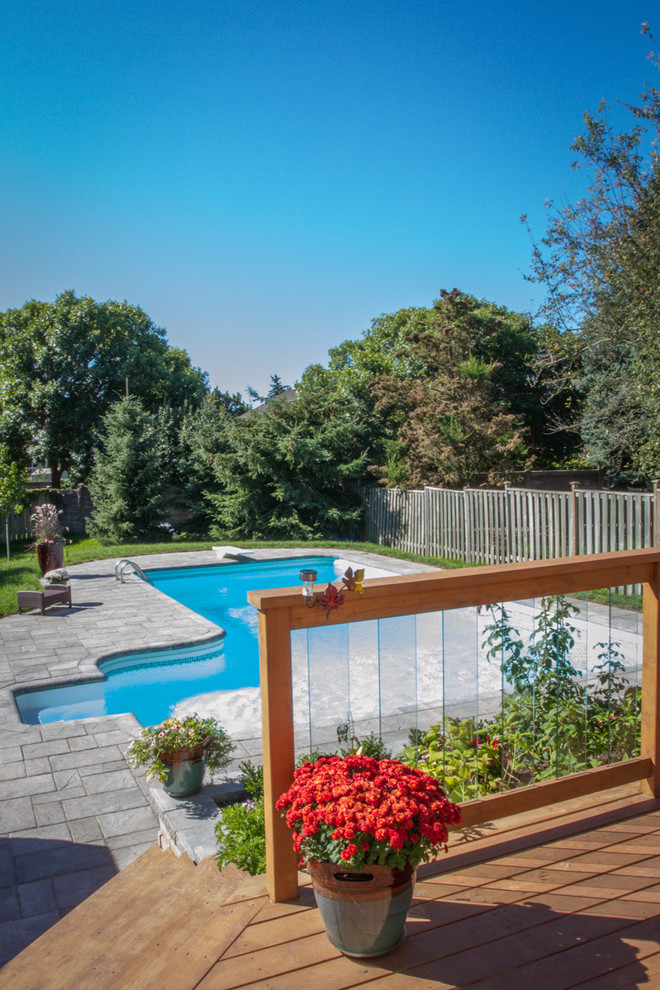 This is an example of a mid-sized contemporary backyard rectangular lap pool in Toronto with brick pavers and with a pool.
