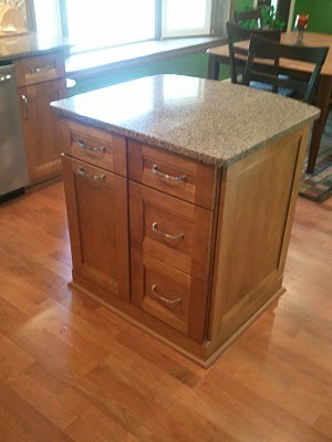 Mid-sized transitional u-shaped medium tone wood floor eat-in kitchen photo in Cincinnati with an undermount sink, flat-panel cabinets, medium tone wood cabinets, quartz countertops, multicolored backsplash, mosaic tile backsplash, stainless steel appliances and an island