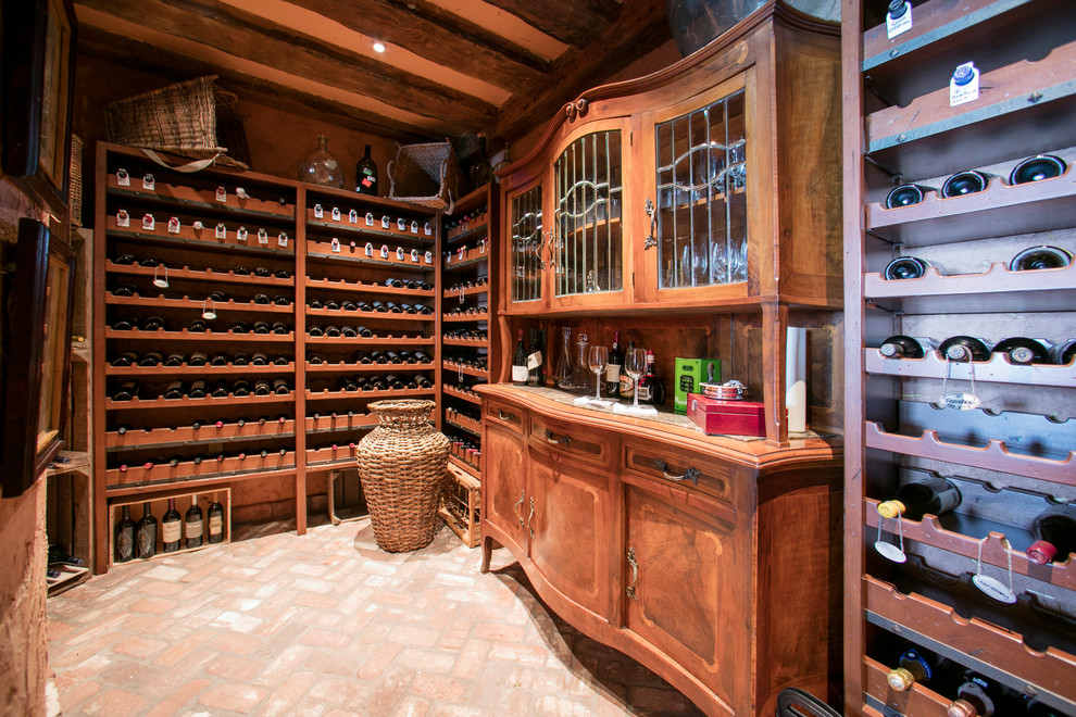 This is an example of a mediterranean wine cellar in Orange County with brick floors and storage racks.