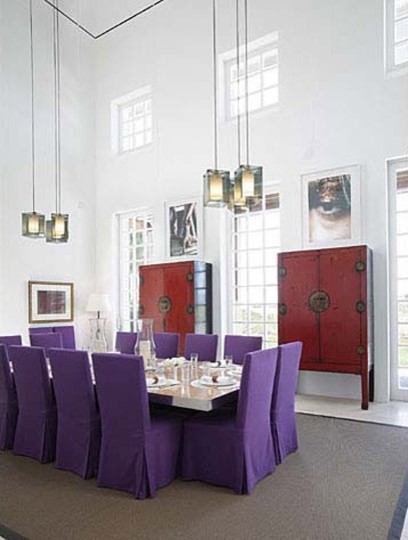 This is an example of a large tropical dining room in Miami with white walls.