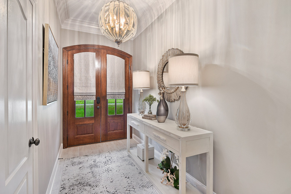 Example of a mid-sized transitional dark wood floor and brown floor foyer design with white walls and a white front door